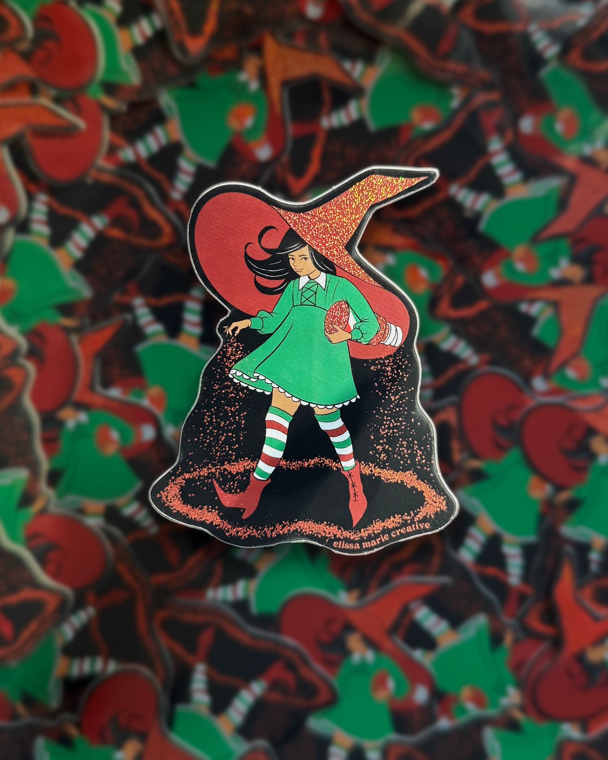 A die-cut glitter sticker featuring a witch that looks like the Morton Salt girl, except she carries Tajin and wears the colors of the Mexican flag.