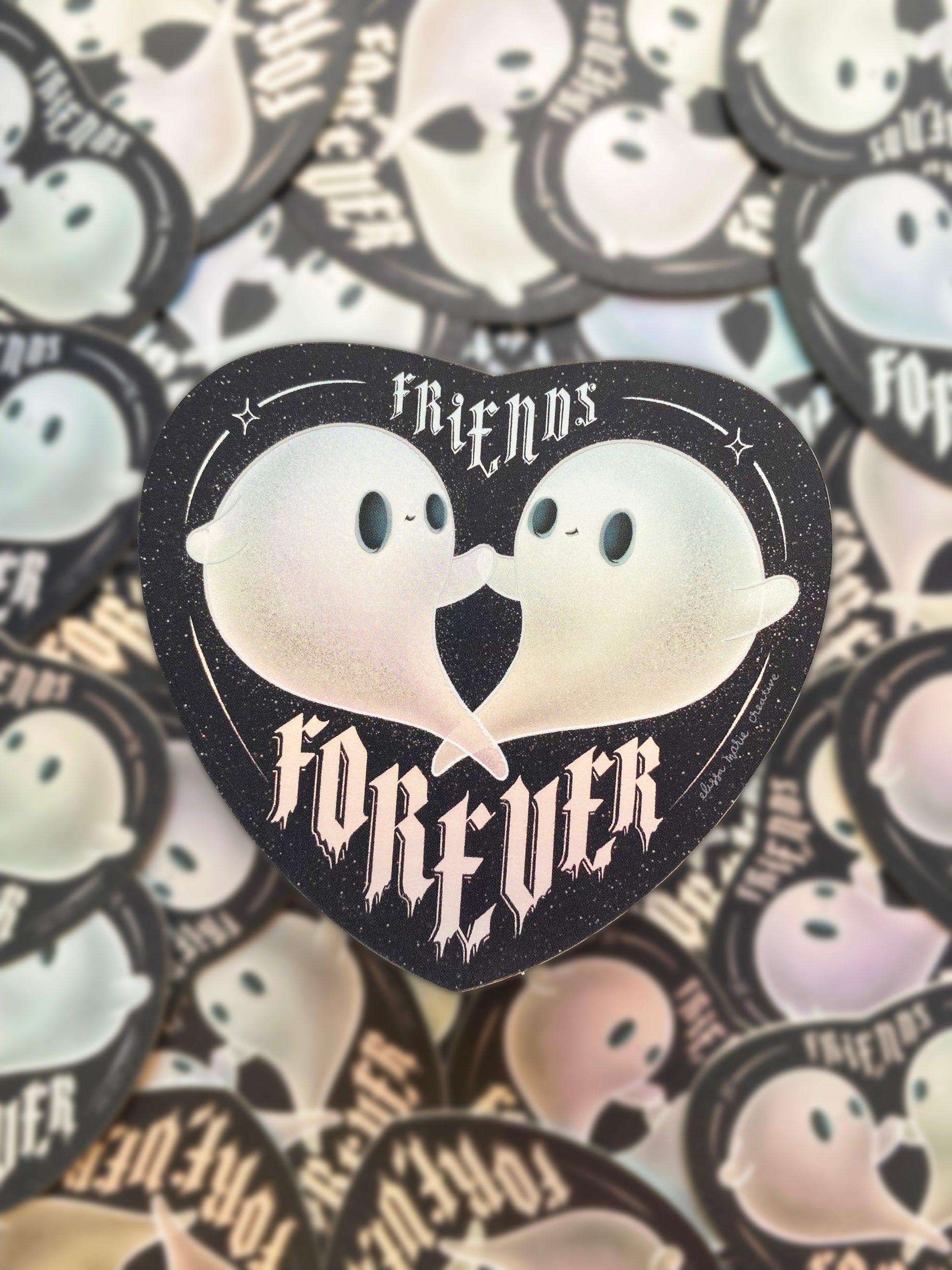 A holographic sticker with a design that reads 'Friends Forever' and features two cartoon ghosts holding hands.