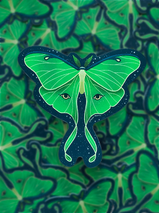 A sticker of a green luna moth with a patterned blue and green background.